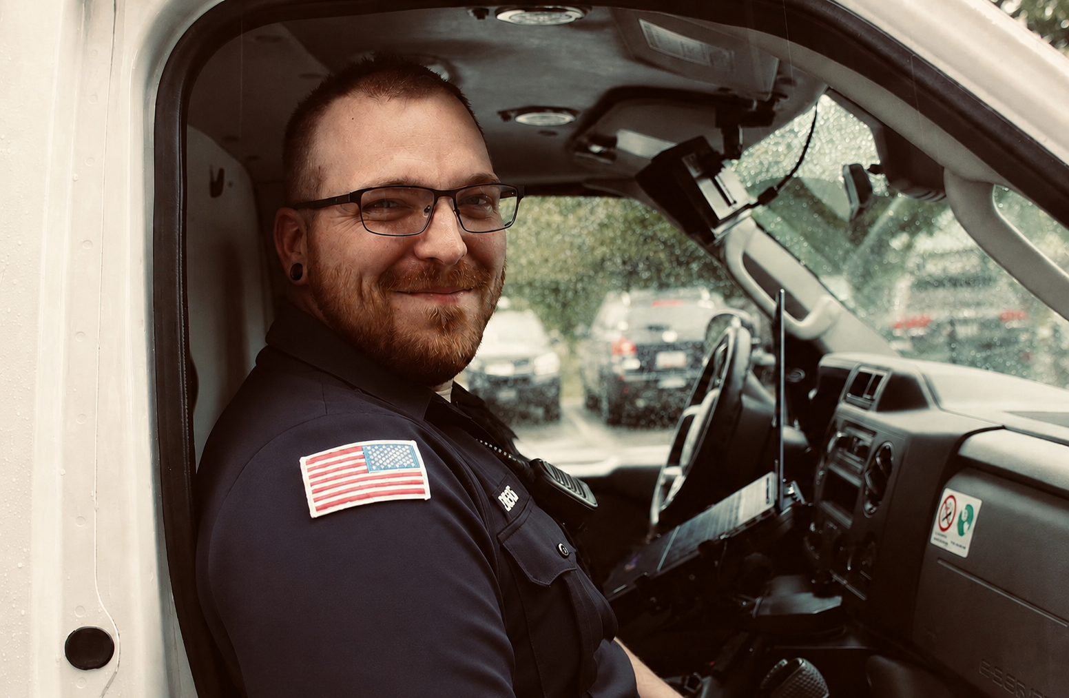 David, founder of IronSight, seated in the cab of an ambulance in uniform